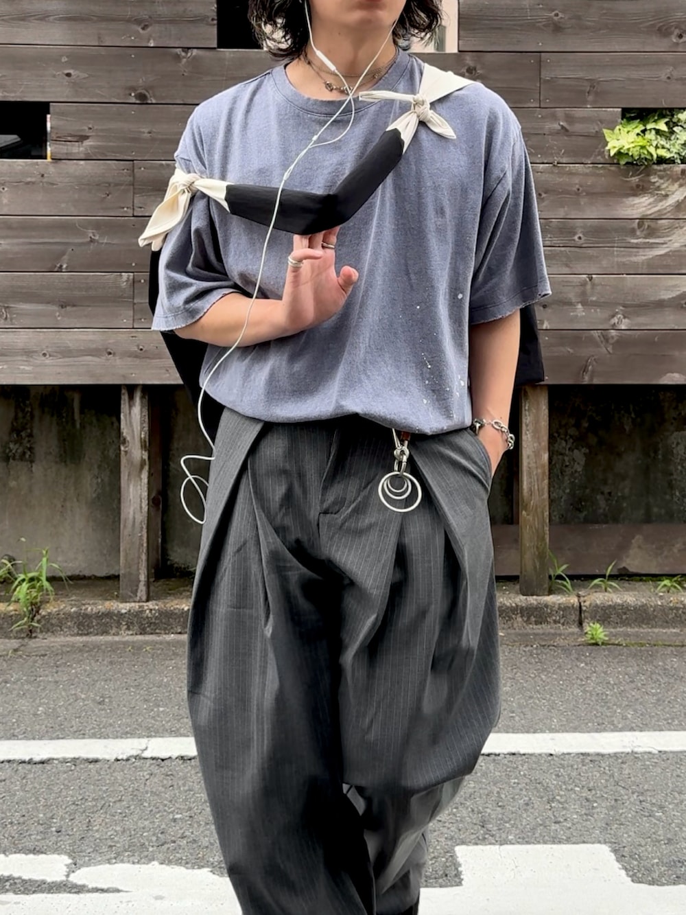 グレー系のスラックス、ブルー系のTシャツ/カットソー、ブラック系のスニーカーを着用したメンズの夏コーディネートの2枚目の写真