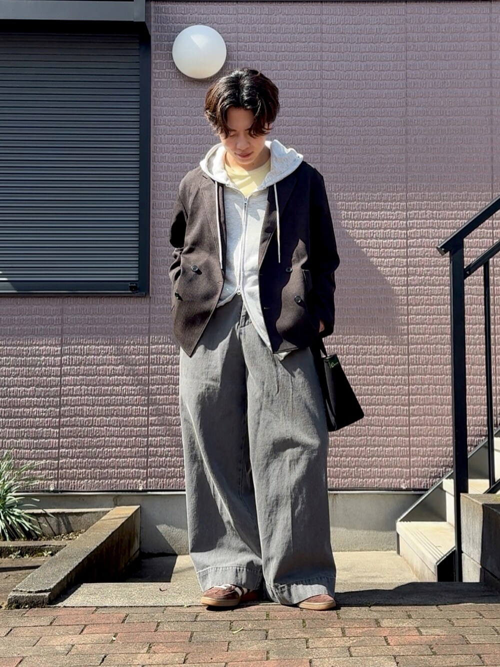 グレー系のパーカー、ブラック系のジャケット/アウター、グレー系のデニムパンツを着用したメンズの春コーディネートの2枚目の写真