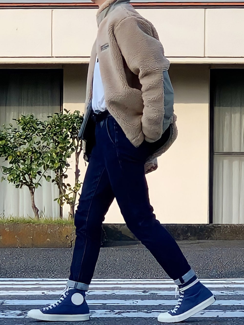 ブルー系のスニーカー、ベージュ系のブルゾン、ブラック系のショルダーバッグを着用したメンズの秋コーディネートの2枚目の写真