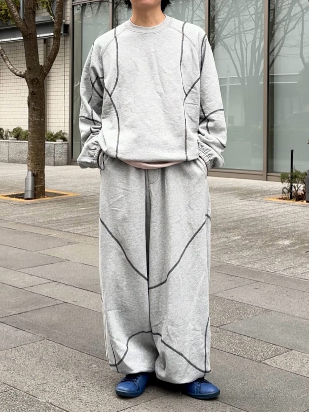 グレー系のスウェットパンツ、グレー系のスウェット、ブラック系のショルダーバッグを着用したメンズの冬コーディネートの3枚目の写真