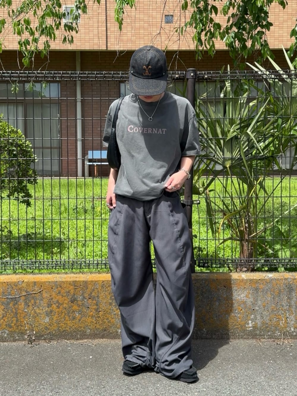 グレー系のデニムパンツ、グレー系のTシャツ/カットソー、ブラック系のスニーカーを着用したメンズの春コーディネートの2枚目の写真
