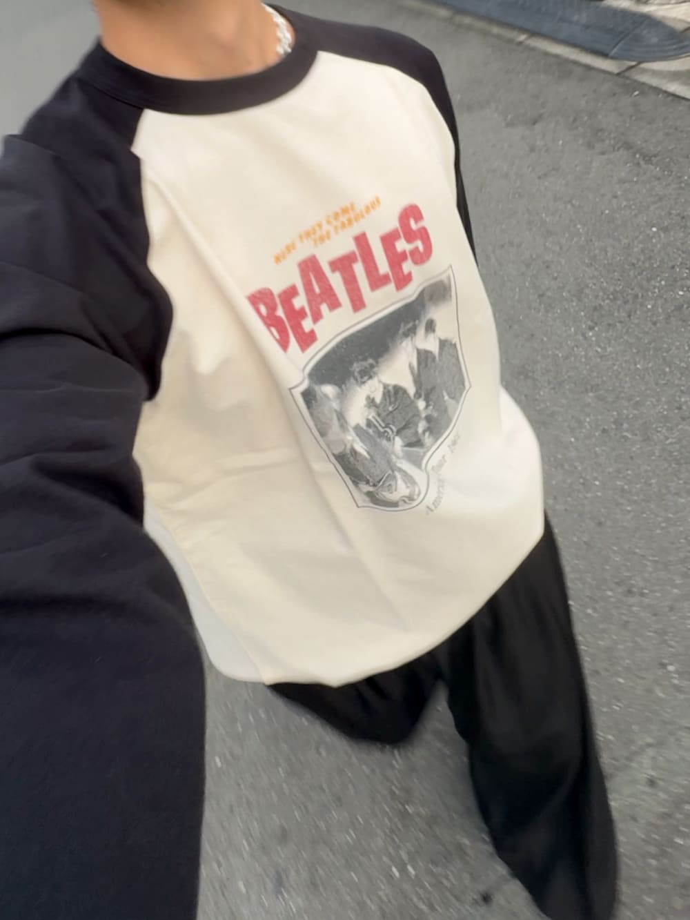 ブラック系のスラックス、ブラック系のTシャツ/カットソー、ブラック系のトートバッグを着用したメンズの秋コーディネートの3枚目の写真