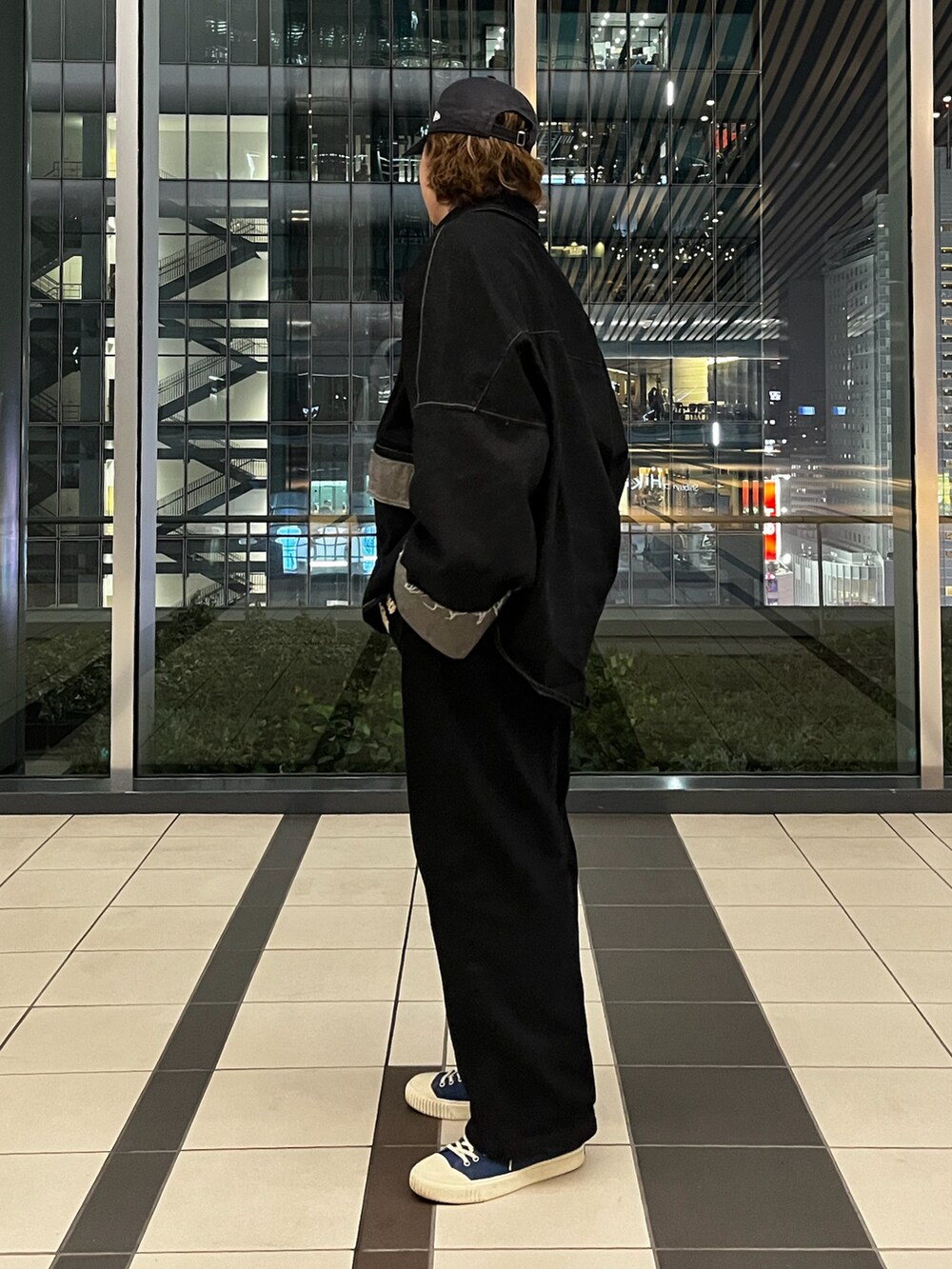 ブルー系のスニーカー、ブラック系のデニムジャケット、ブラック系のデニムパンツを着用したメンズの春コーディネートの2枚目の写真