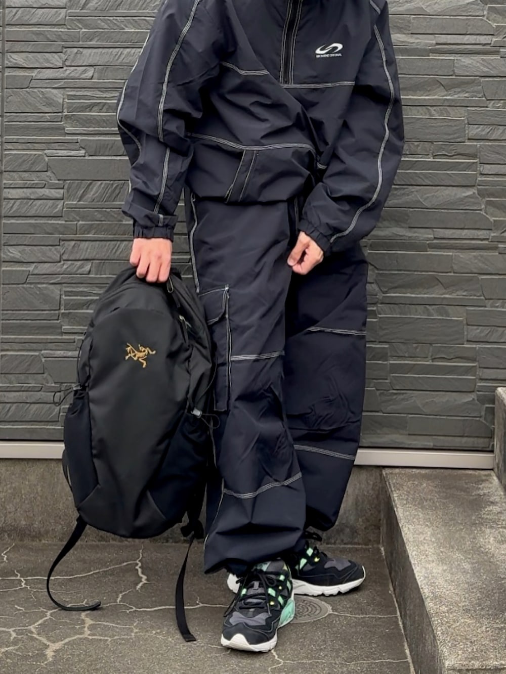 ブラック系のスニーカー、ブラック系のセットアップ、ブラック系のカーゴパンツを着用したメンズの春コーディネートの3枚目の写真