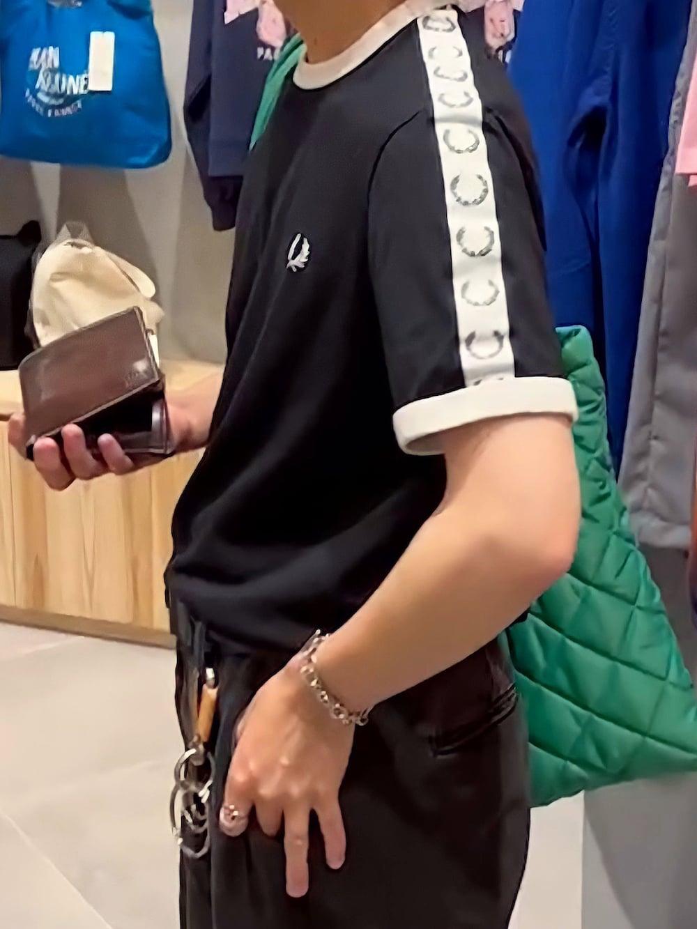 ブラック系のTシャツ/カットソー、グリーン系のトートバッグ、ホワイト系のスニーカーを着用したメンズの夏コーディネートの2枚目の写真