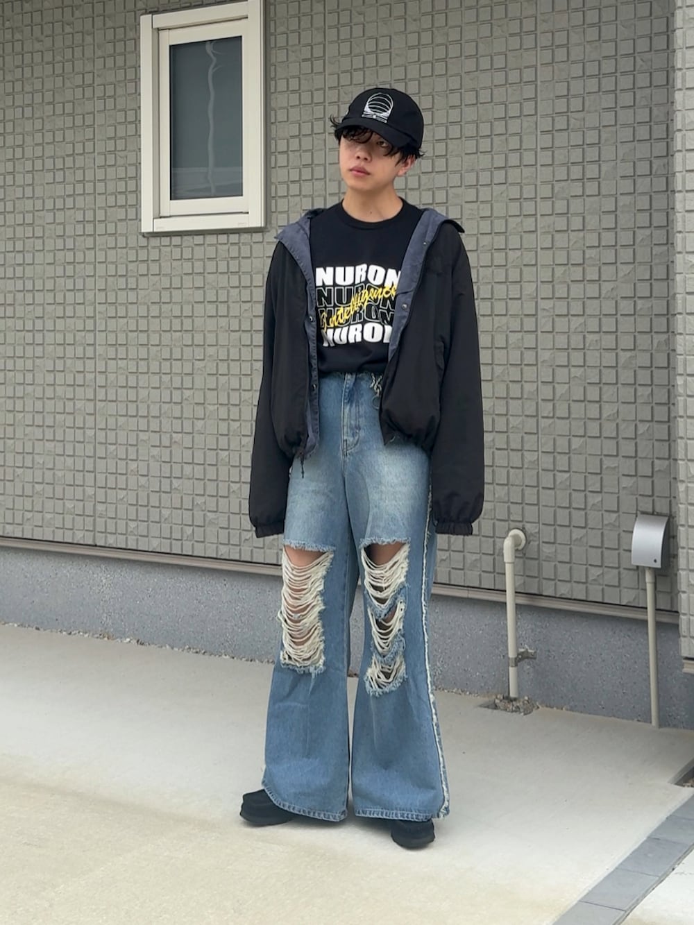 ブルー系のデニムパンツ、ブラック系のTシャツ/カットソー、ベージュ系のブルゾンを着用したメンズの秋コーディネートの2枚目の写真