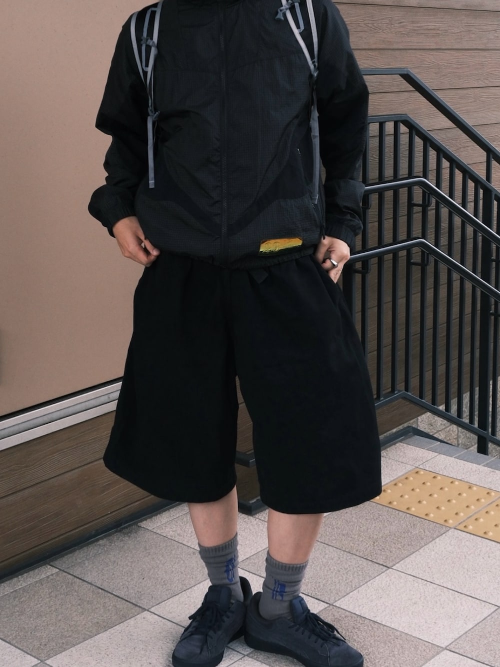 ブルー系のスニーカー、ホワイト系のバックパック/リュック、ブラック系のその他パンツを着用したメンズの秋コーディネートの2枚目の写真
