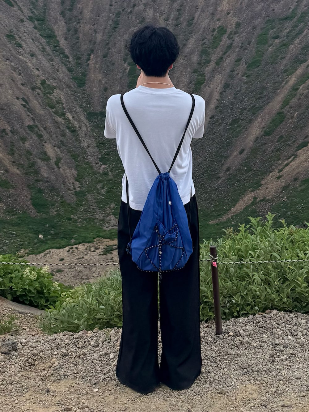 ホワイト系のTシャツ/カットソー、ブラック系のスラックス、ブルー系のバックパック/リュックを着用したメンズの夏コーディネートの2枚目の写真