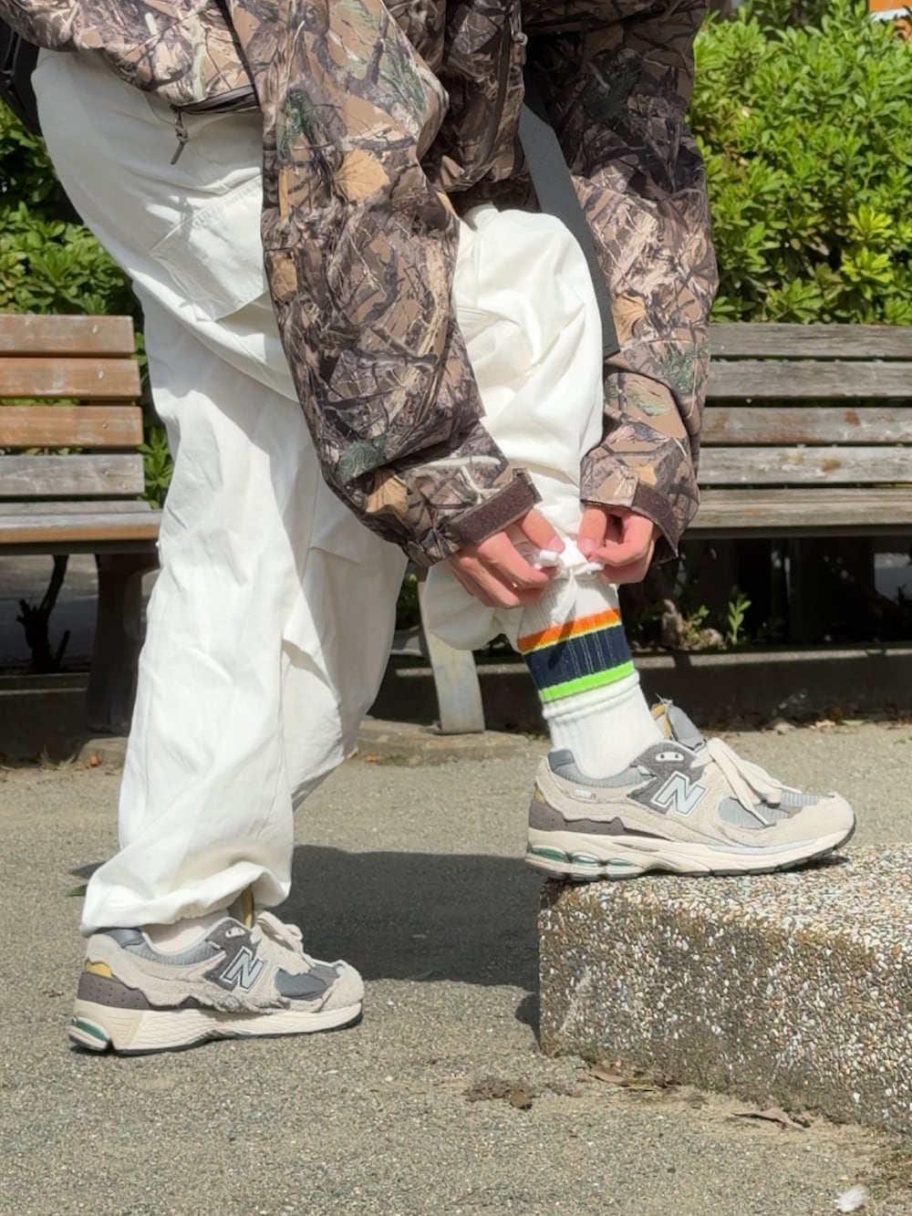 ホワイト系のカーゴパンツ、グレー系のスニーカー、ブラウン系のジャケット/アウターを着用したメンズの秋コーディネートの5枚目の写真