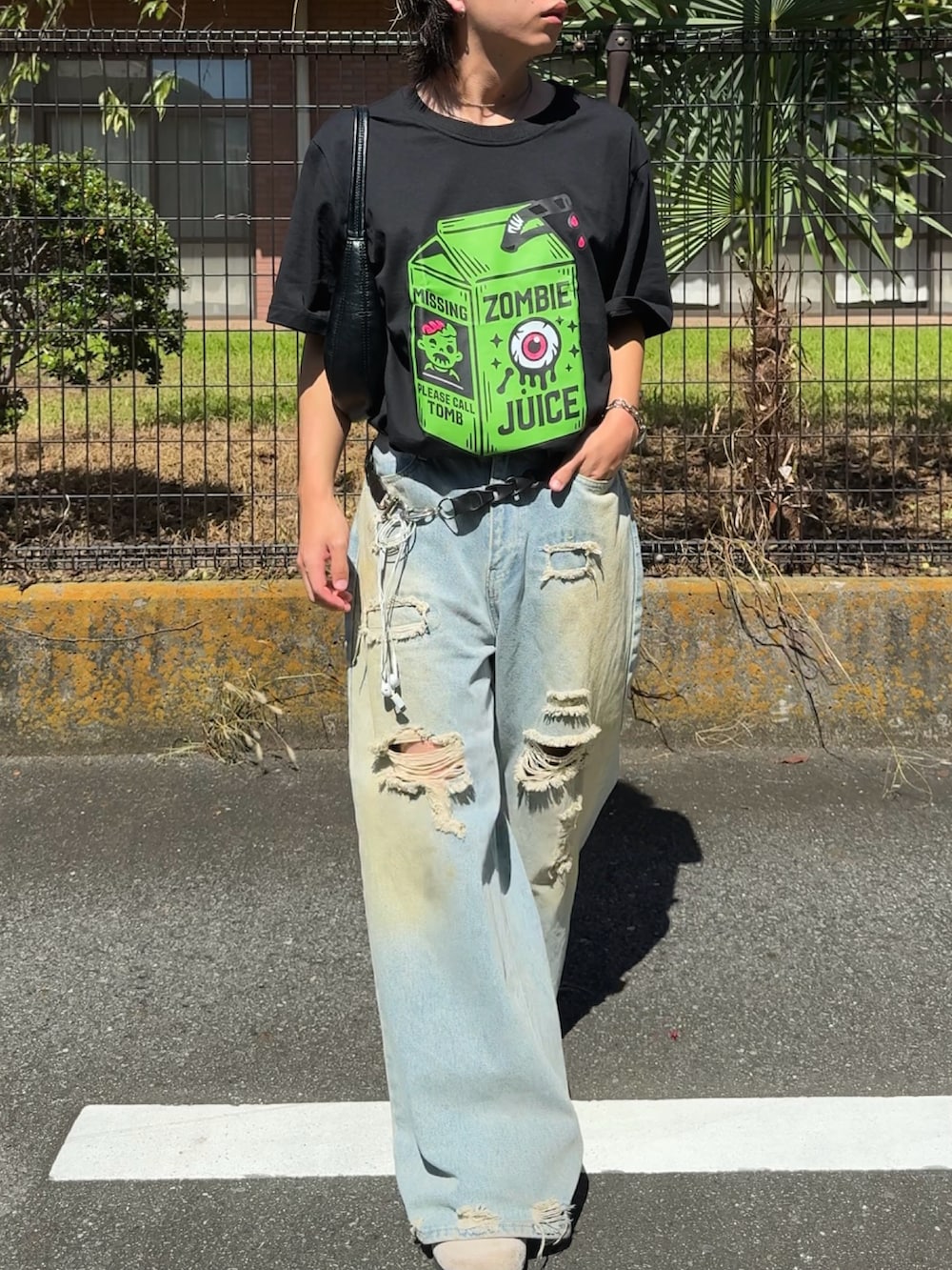 ブルー系のデニムパンツ、ブラック系のTシャツ/カットソー、ベージュ系のサンダルを着用したメンズの秋コーディネートの2枚目の写真