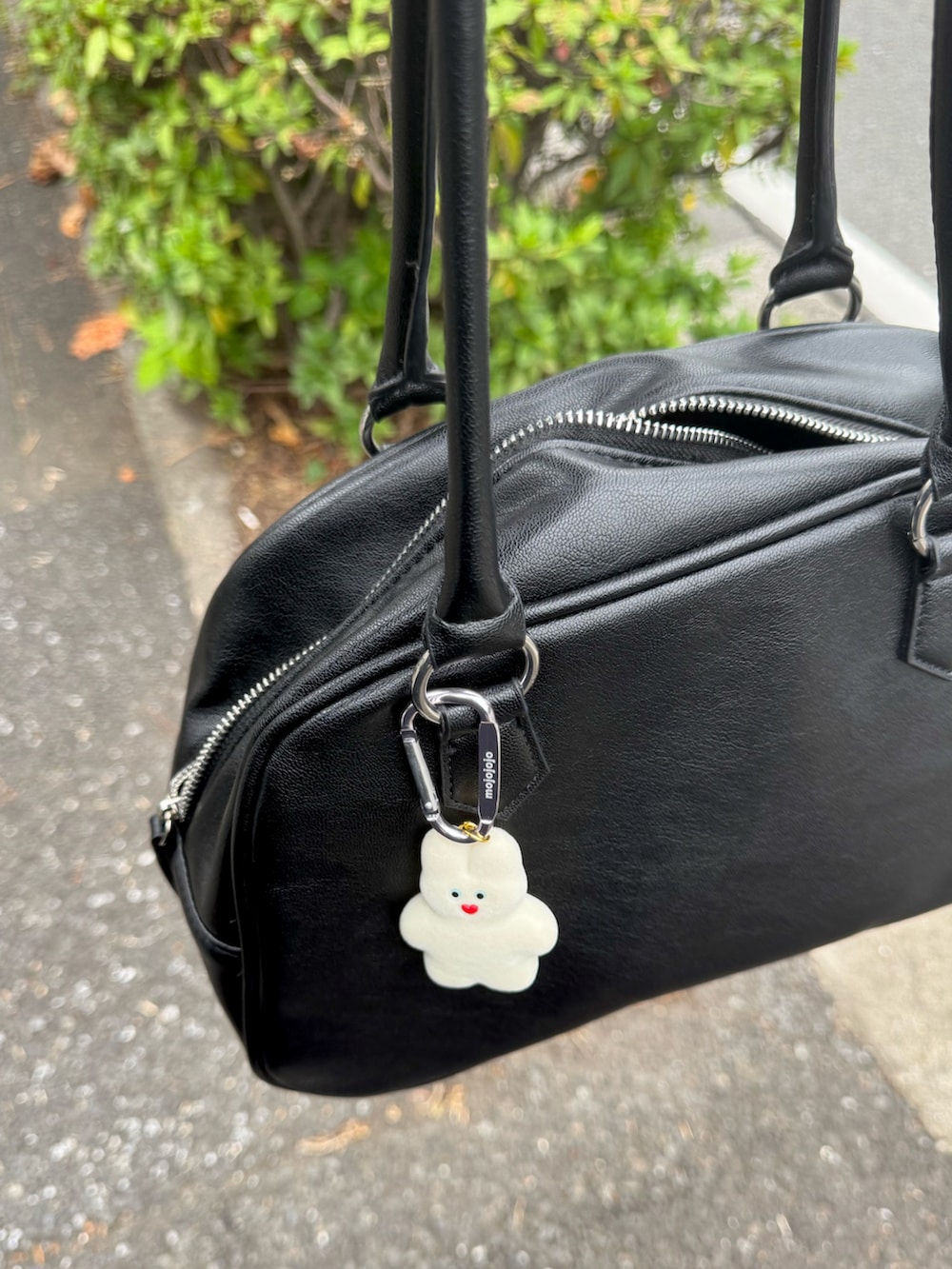 レッド系のブルゾン、ブルー系のテーラードジャケット、レッド系のボストンバッグを着用したメンズの秋コーディネートの4枚目の写真