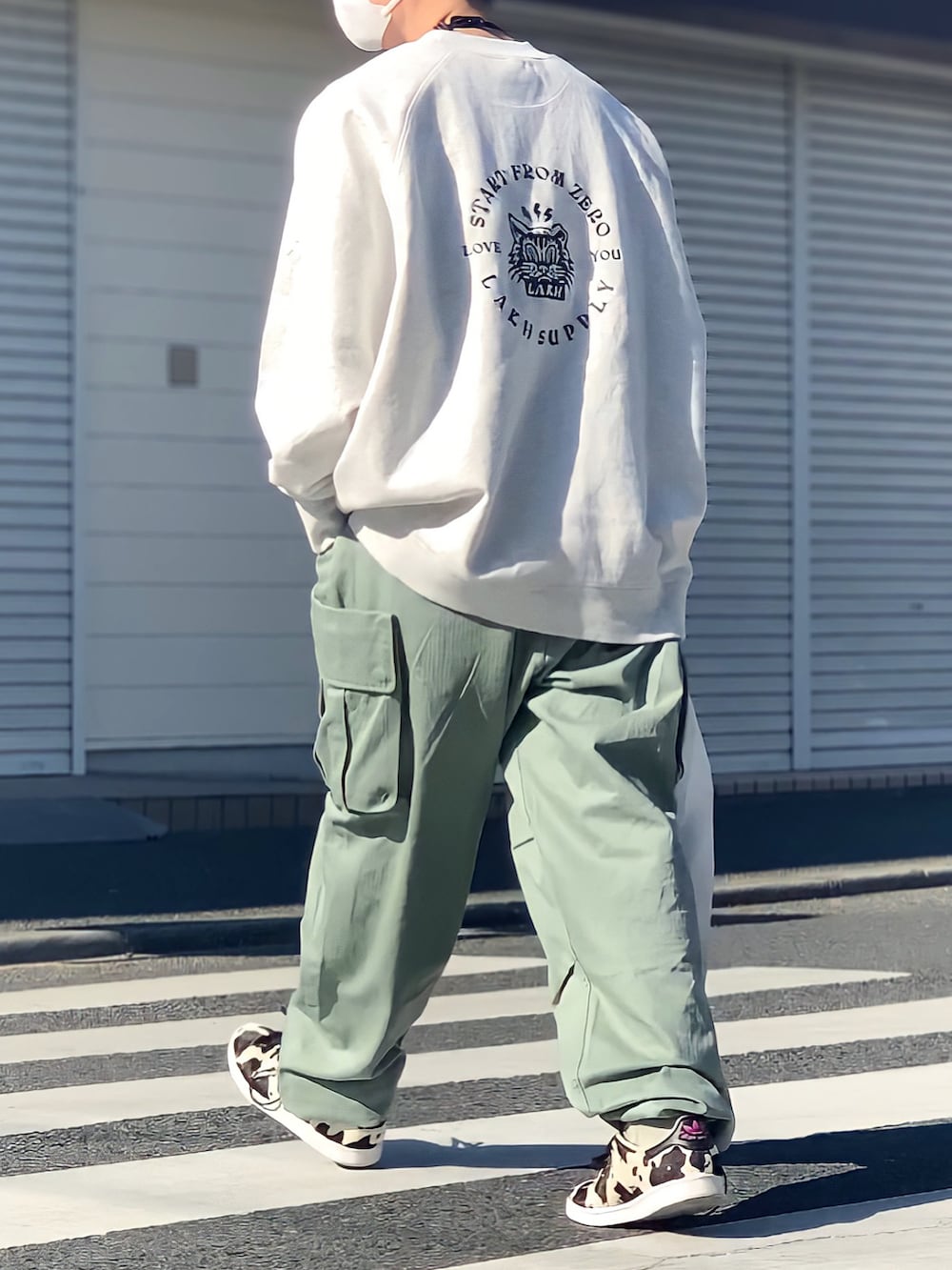 ブラック系のスニーカー、グレー系のスウェット、グリーン系のカーゴパンツを着用したメンズの冬コーディネートの4枚目の写真