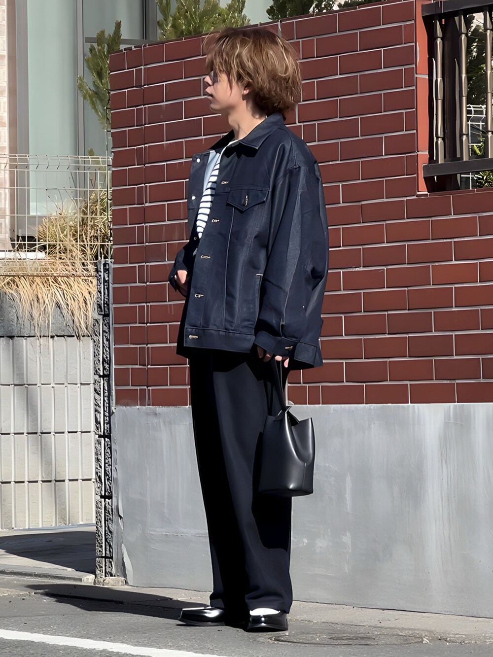 ブルー系のその他パンツ、ブラック系のハンドバッグ、ブラック系のローファーを着用したメンズの冬コーディネートの2枚目の写真