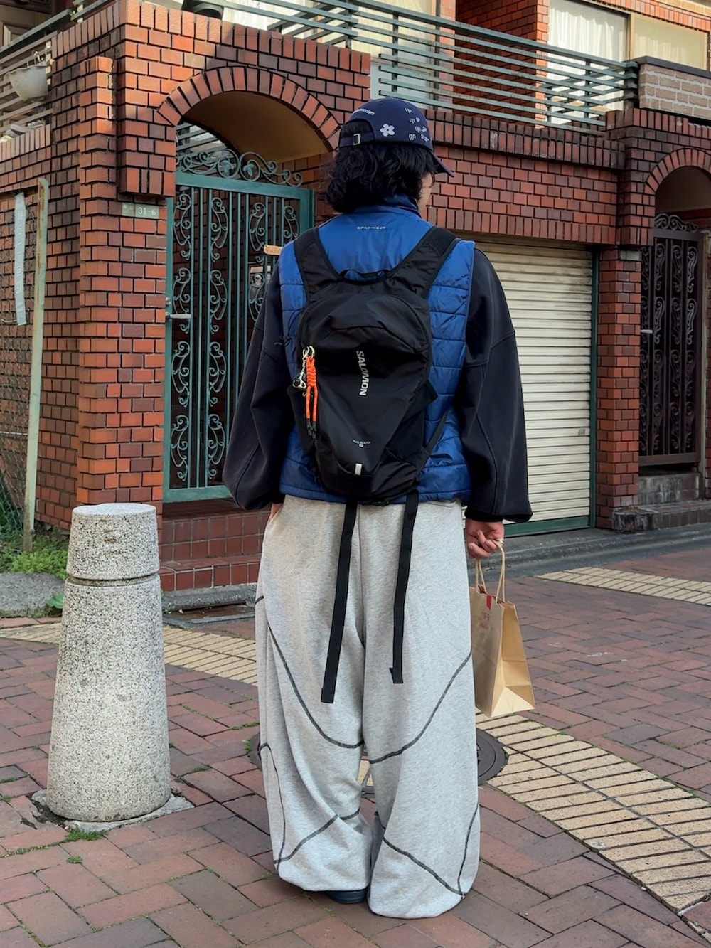 グレー系のスウェットパンツ、ブルー系のスウェット、ブルー系のダウンベストを着用したメンズの春コーディネートの4枚目の写真