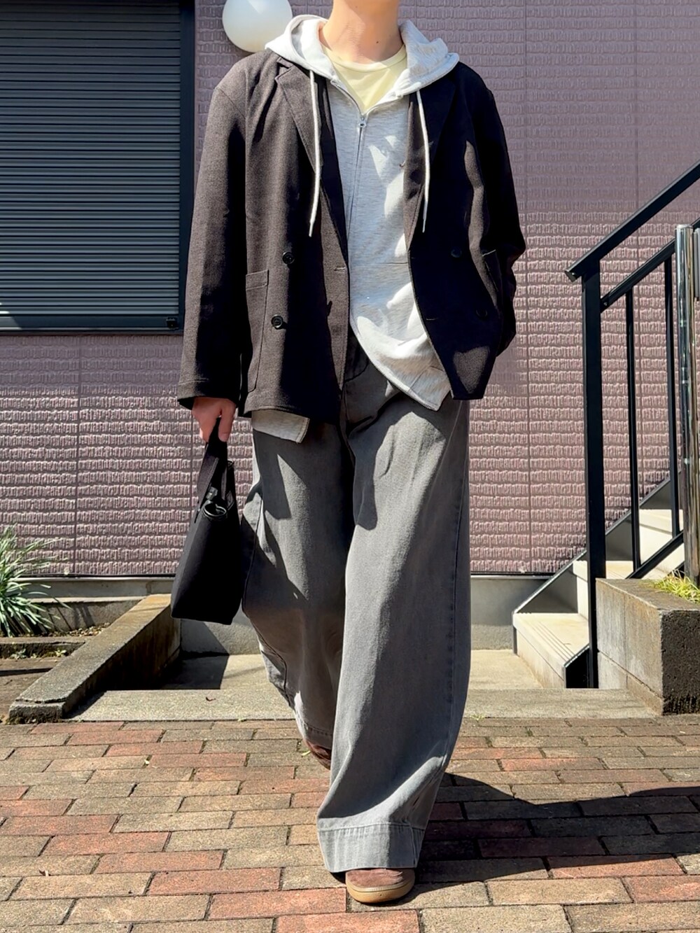 グレー系のパーカー、ブラック系のジャケット/アウター、グレー系のデニムパンツを着用したメンズの春コーディネートの3枚目の写真