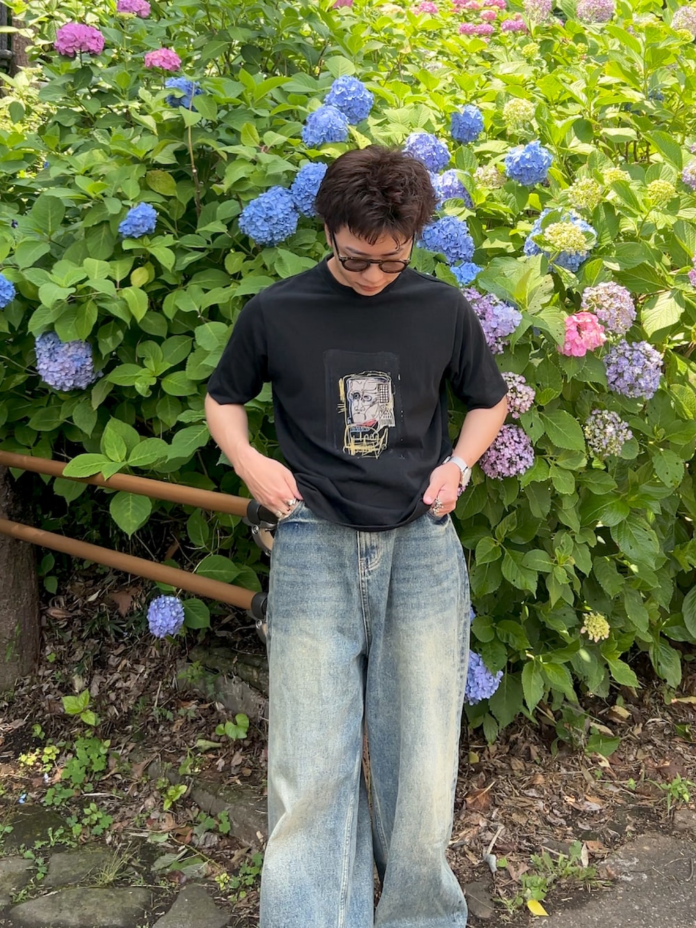 その他のTシャツ/カットソー、ブルー系のデニムパンツ、ブラック系のハンドバッグを着用したメンズの夏コーディネートの2枚目の写真