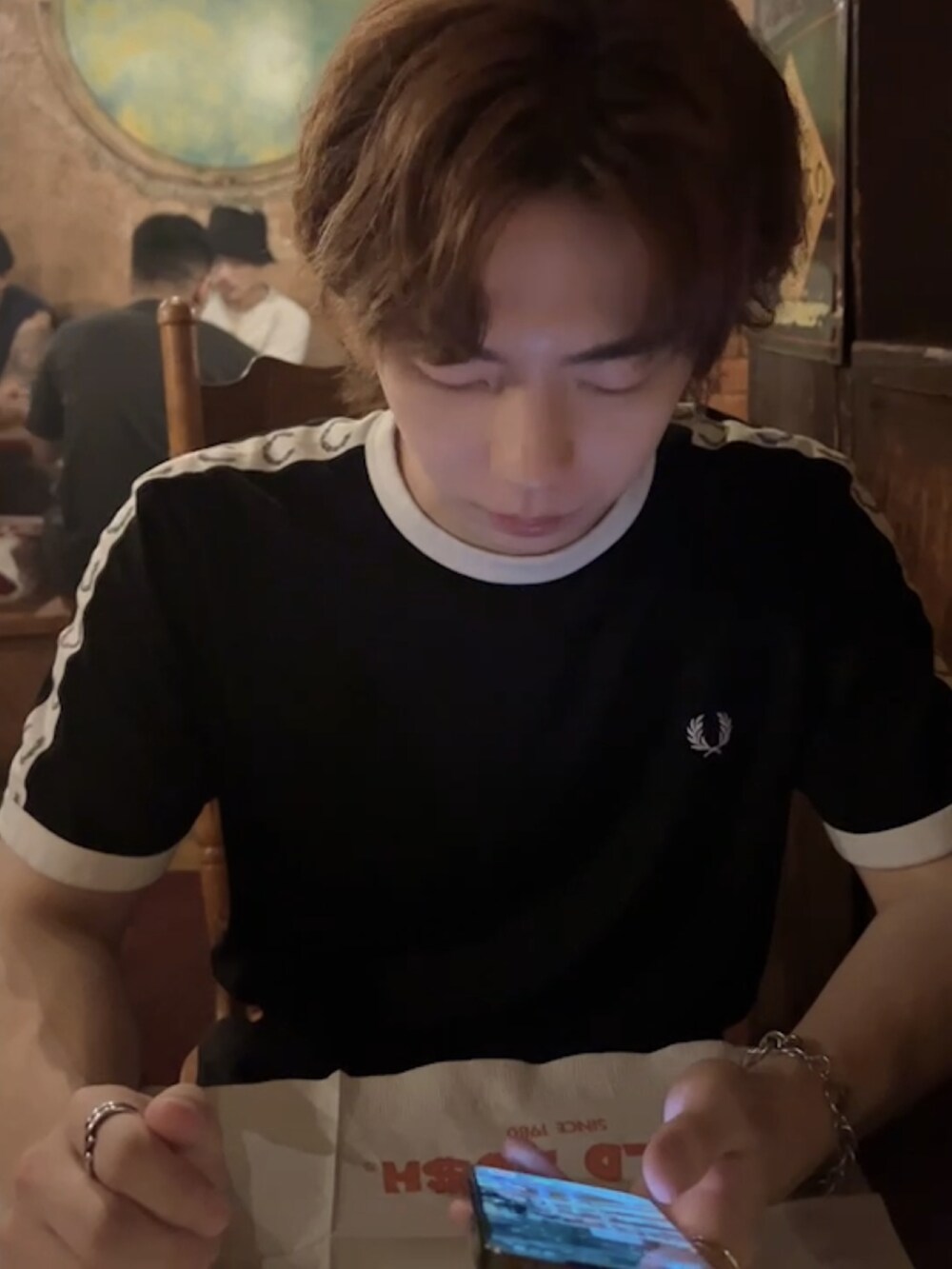 ブラック系のTシャツ/カットソー、グリーン系のトートバッグ、ホワイト系のスニーカーを着用したメンズの夏コーディネートの3枚目の写真