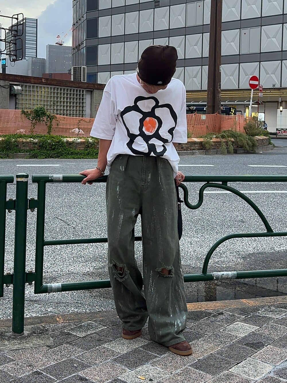 ホワイト系のTシャツ/カットソー、グリーン系のデニムパンツ、ブラウン系のスニーカーを着用したメンズの秋コーディネートの2枚目の写真