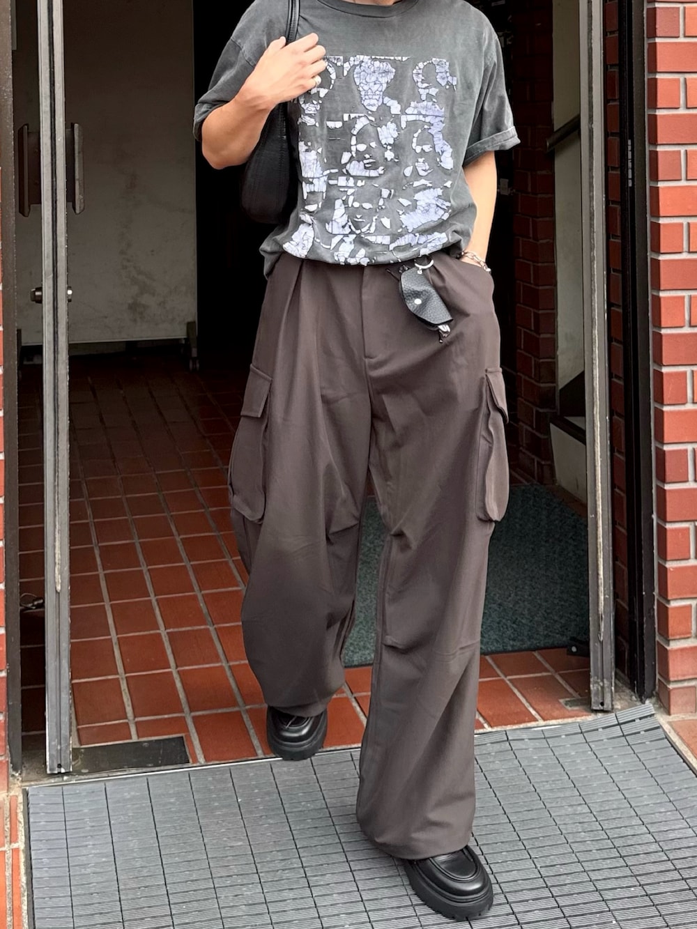グレー系のその他パンツ、ブラック系のTシャツ/カットソー、ブラック系のシューズを着用したメンズの夏コーディネートの2枚目の写真