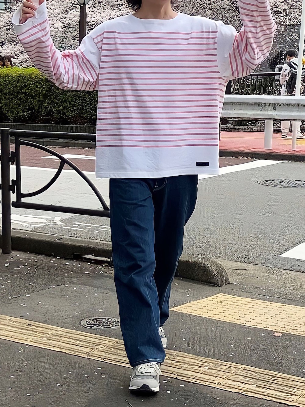 ブルー系のデニムパンツ、ピンク系のTシャツ/カットソー、グレー系のスニーカーを着用したメンズの春コーディネートの2枚目の写真