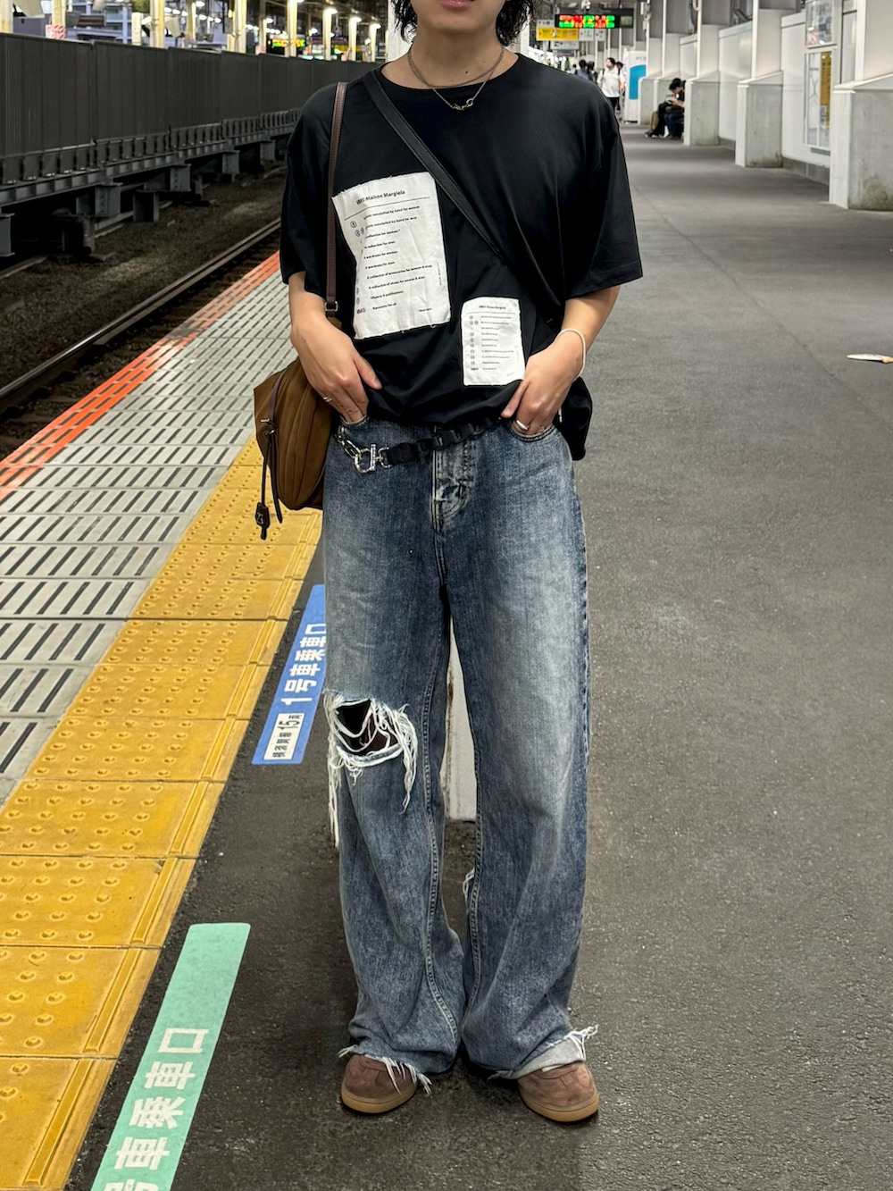 ブルー系のデニムパンツ、ブラック系のトップス、ブラウン系のスニーカーを着用したメンズの秋コーディネートの2枚目の写真