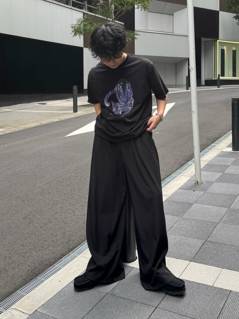 ブラック系のスラックス、ブラック系のTシャツ/カットソー、ブラック系のスニーカーを着用したメンズの夏コーディネートの2枚目の写真