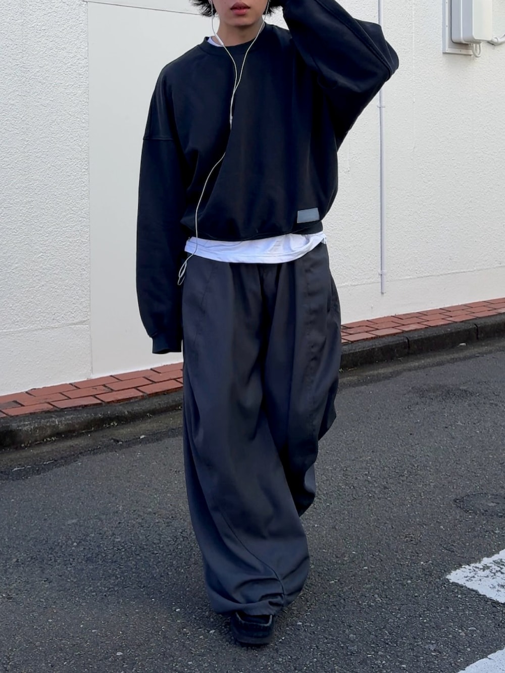 グレー系のデニムパンツ、ブルー系のスウェット、ブラック系のスニーカーを着用したメンズの冬コーディネートの2枚目の写真