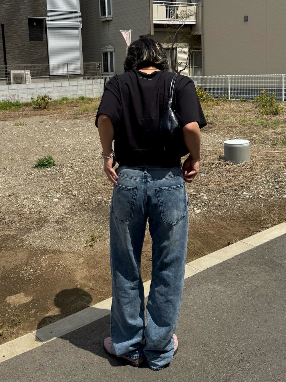 ピンク系のスニーカー、ブルー系のデニムパンツ、ブラック系のTシャツ/カットソーを着用したメンズの春コーディネートの2枚目の写真