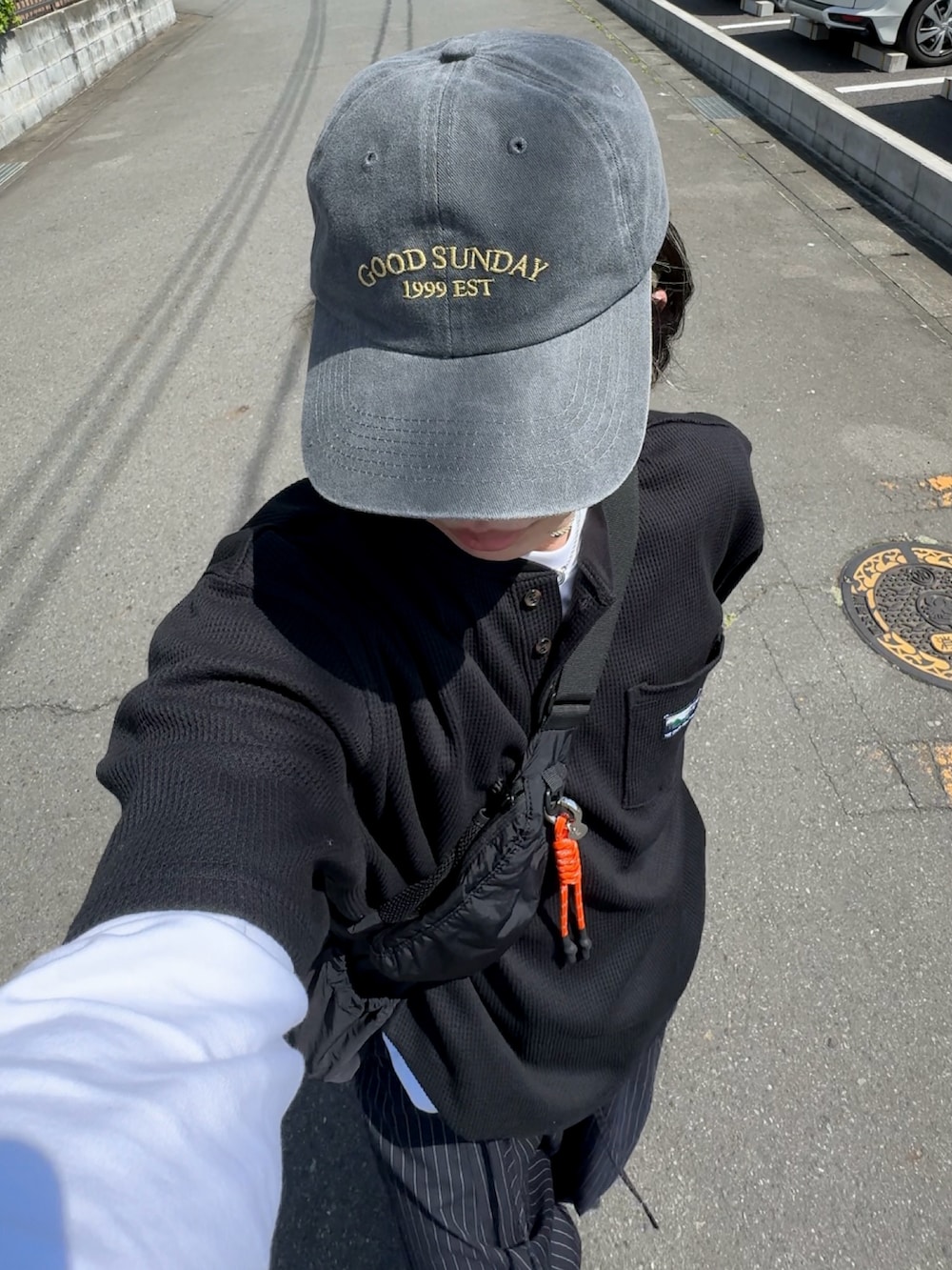 ブラック系のTシャツ/カットソー、グレー系のスラックス、ブラック系のスニーカーを着用したメンズの春コーディネートの3枚目の写真