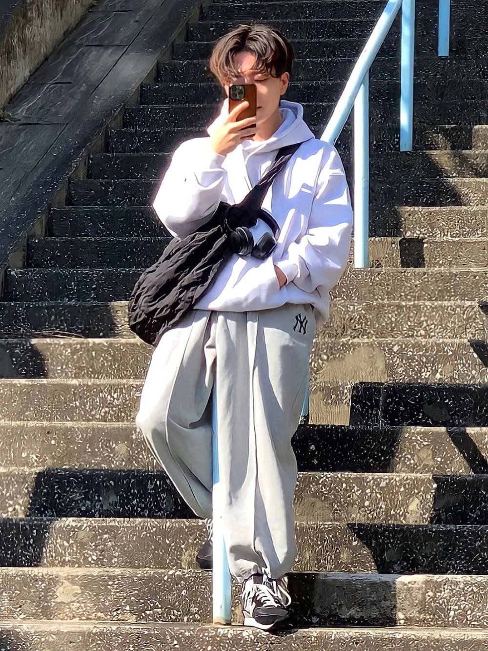 その他のスウェットパンツ、ブラック系のショルダーバッグ、グレー系のパーカーを着用したメンズの秋コーディネートの2枚目の写真