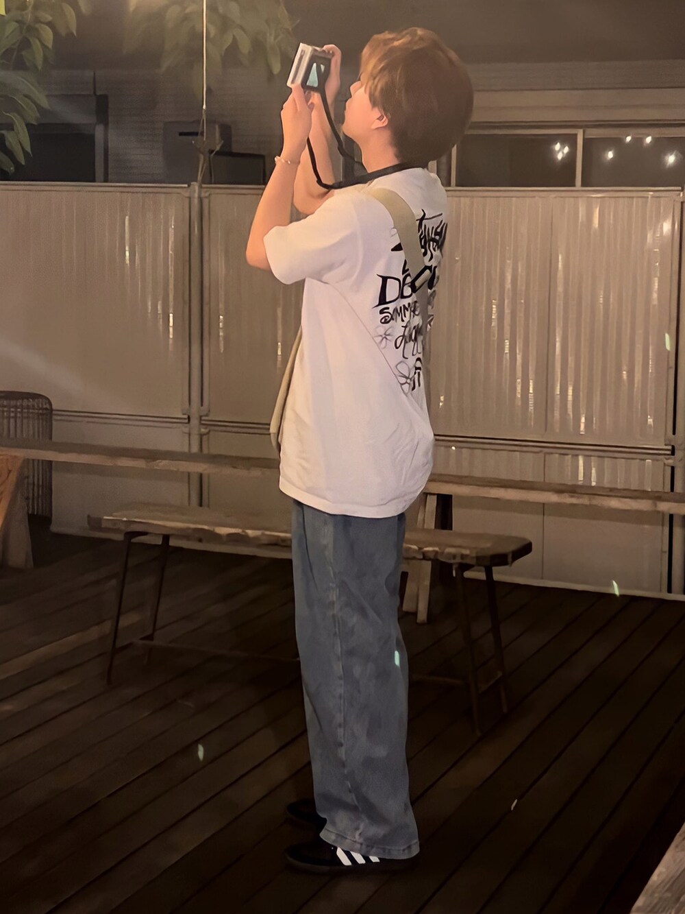 ブルー系のデニムパンツ、ホワイト系のTシャツ/カットソー、ベージュ系のメッセンジャーバッグを着用したメンズの夏コーディネートの3枚目の写真