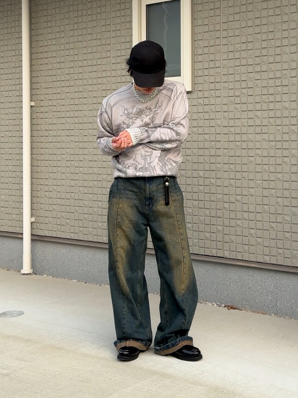 グレー系のニット/セーター、ブルー系のデニムパンツ、ブラック系のローファーを着用したメンズの秋コーディネートの2枚目の写真