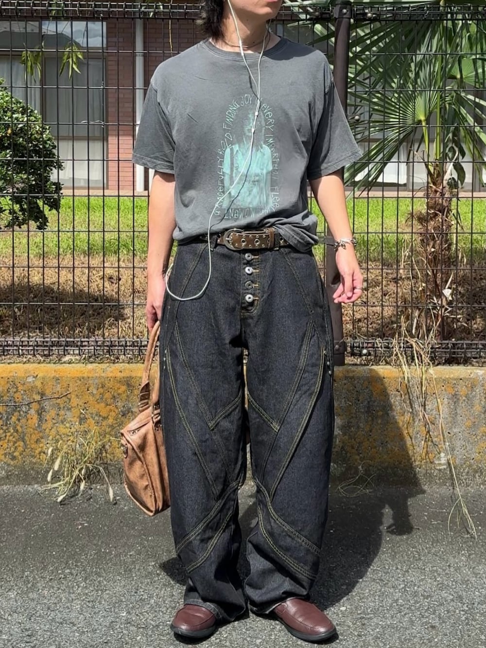 ブルー系のデニムパンツ、グレー系のTシャツ/カットソー、ブラウン系のボストンバッグを着用したメンズの秋コーディネートの2枚目の写真