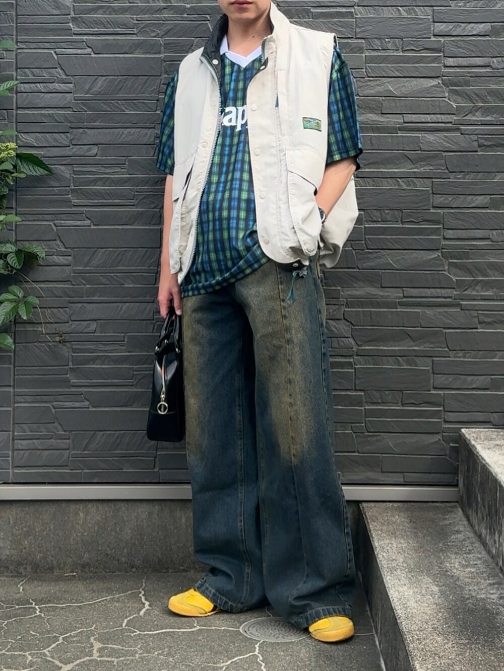 ホワイト系のベスト、ブルー系のデニムパンツ、ブラック系のトップスを着用したメンズの夏コーディネートの2枚目の写真