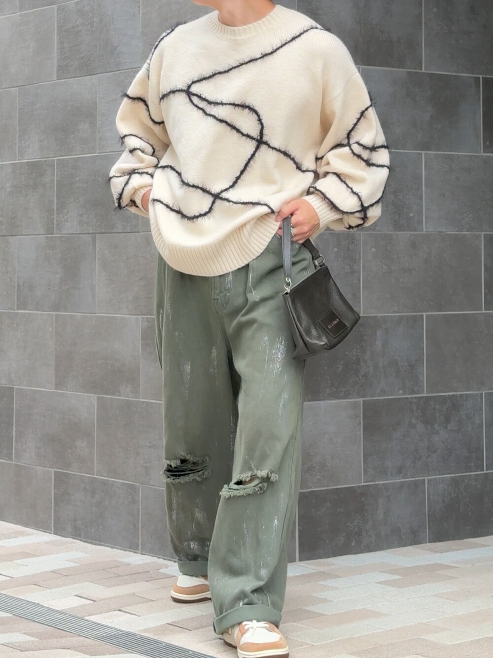 グリーン系のデニムパンツ、ホワイト系のニット/セーター、ベージュ系のスニーカーを着用したメンズの秋コーディネートの3枚目の写真