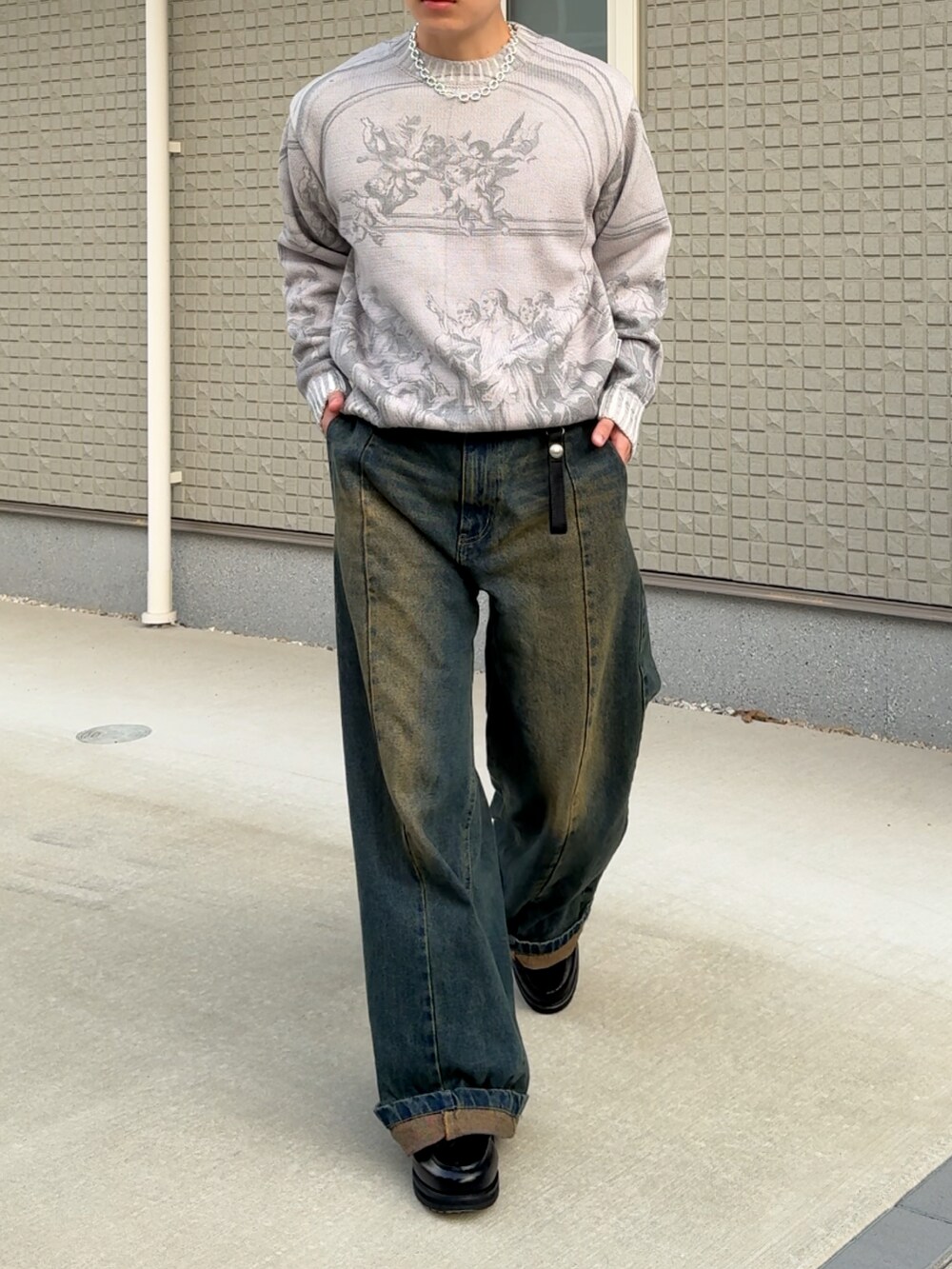 グレー系のニット/セーター、ブルー系のデニムパンツ、ブラック系のローファーを着用したメンズの秋コーディネートの3枚目の写真