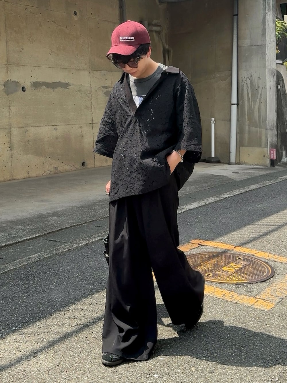 ブラック系のポロシャツ、ブラック系のショルダーバッグ、ブラック系のスラックスを着用したメンズの夏コーディネートの2枚目の写真