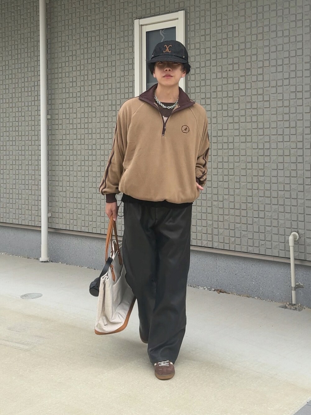 ブラック系のその他パンツ、ベージュ系のボストンバッグ、ブラウン系のスニーカーを着用したメンズの秋コーディネートの2枚目の写真