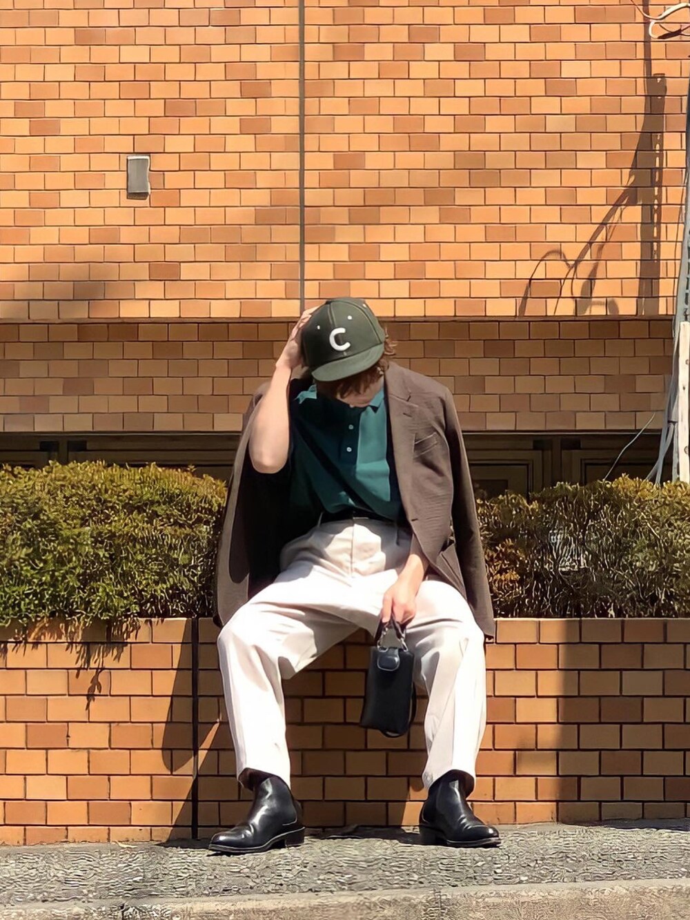 ブラウン系のジャケット/アウター、グリーン系のポロシャツ、ホワイト系のその他パンツを着用したメンズの春コーディネートの2枚目の写真