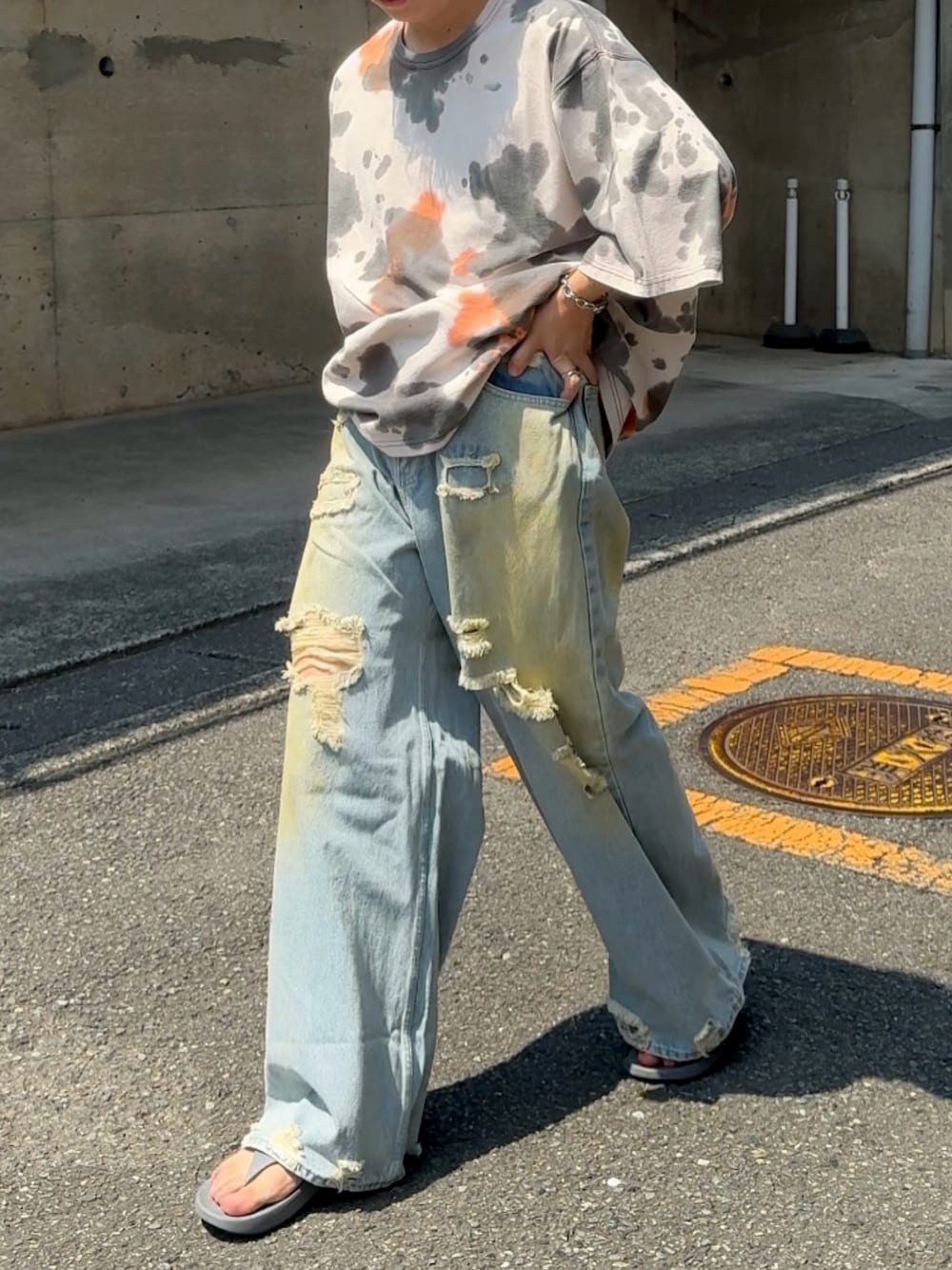グレー系のサンダル、ブルー系のデニムパンツ、ブラック系のTシャツ/カットソーを着用したメンズの夏コーディネートの2枚目の写真
