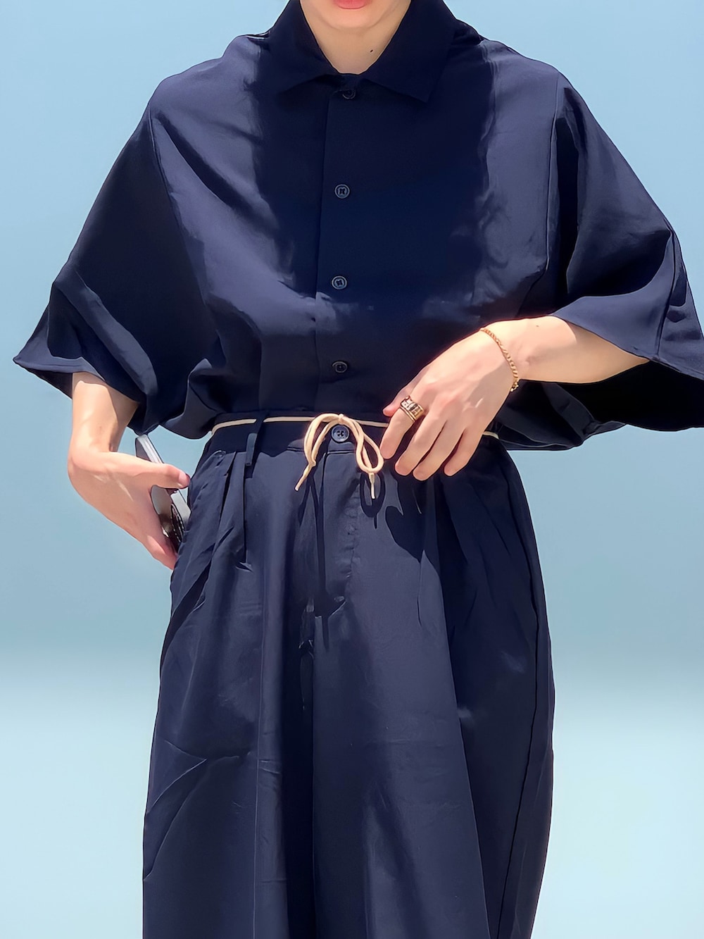 ブラック系のドレスシューズ、ブルー系のセットアップ、ゴールド系のブレスレットを着用したメンズの夏コーディネートの2枚目の写真