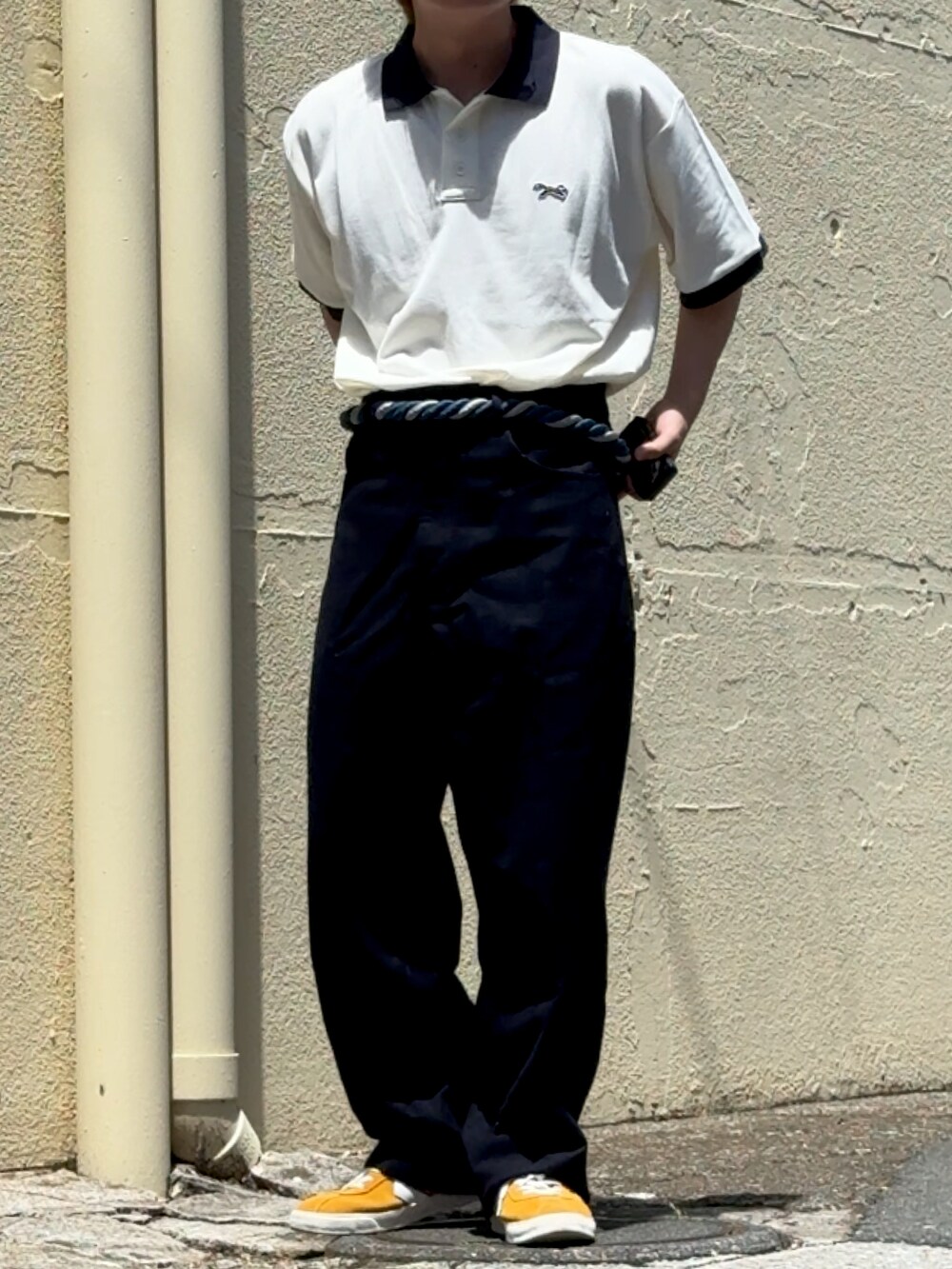 イエロー系のスニーカー、ブルー系のその他パンツ、ホワイト系のポロシャツを着用したメンズの夏コーディネートの3枚目の写真