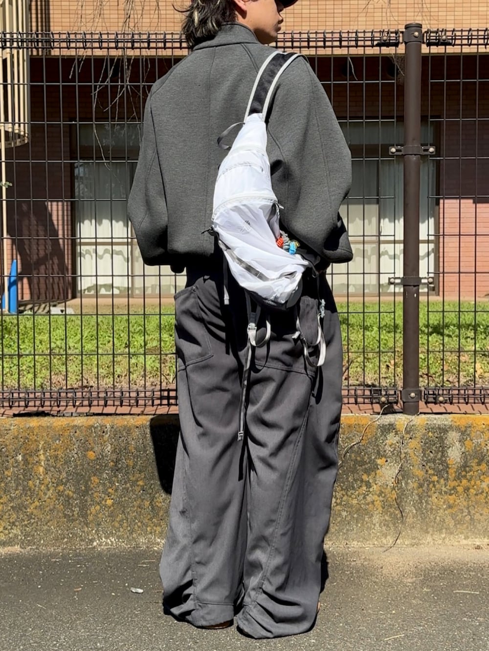 ホワイト系のバックパック/リュック、グレー系のデニムパンツ、グレー系のジャケット/アウターを着用したメンズの秋コーディネートの2枚目の写真