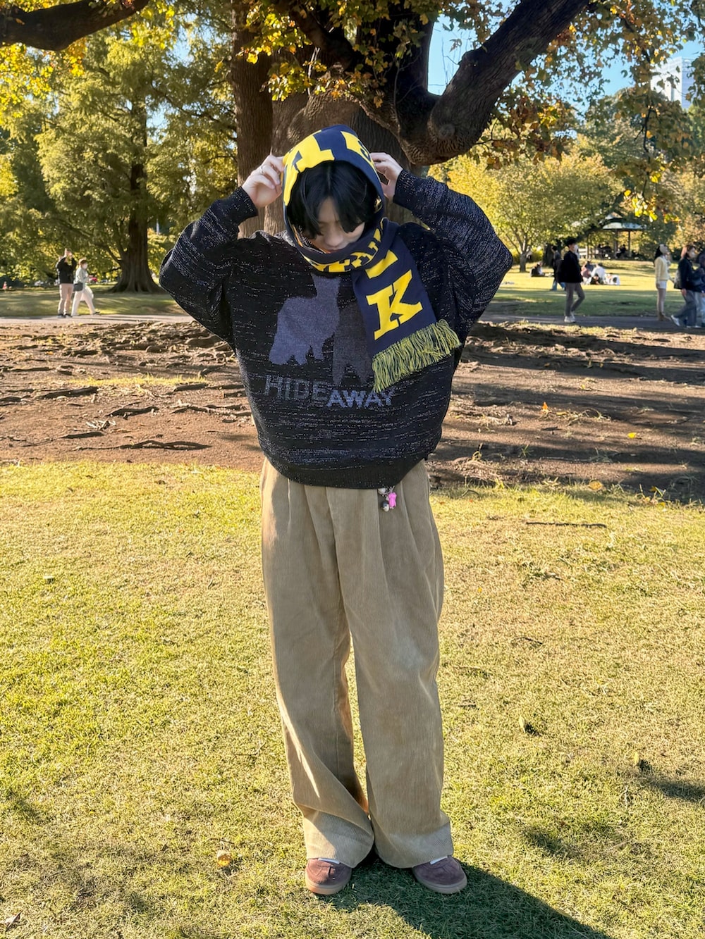 ベージュ系のその他パンツ、ブラック系のニット/セーター、ブラウン系のスニーカーを着用したメンズの秋コーディネートの2枚目の写真