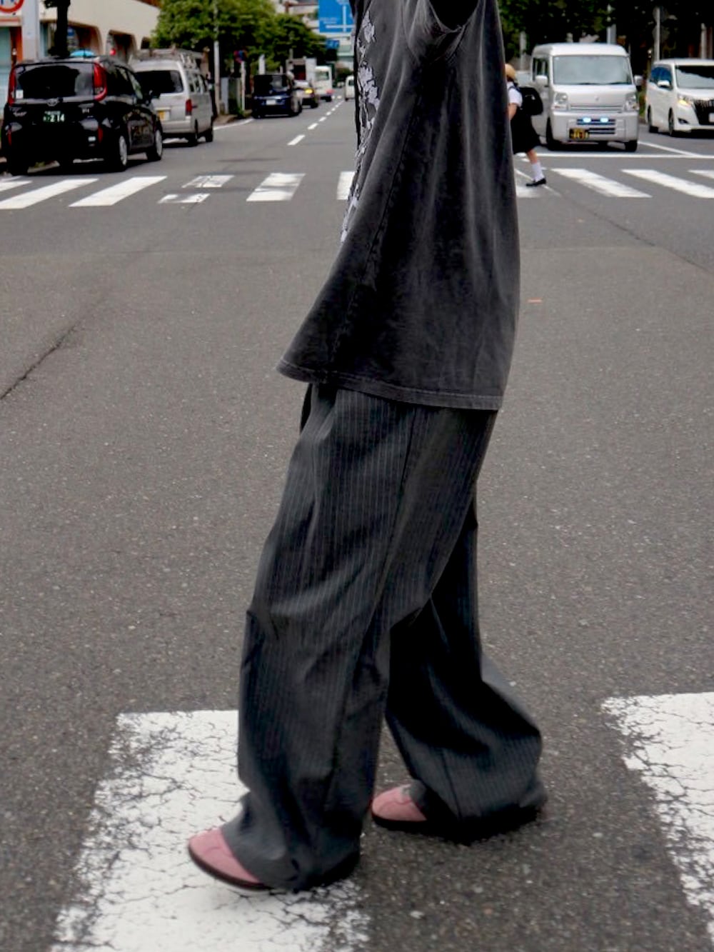 ブラック系のTシャツ/カットソー、グレー系のスラックス、ピンク系のスニーカーを着用したメンズの秋コーディネートの2枚目の写真
