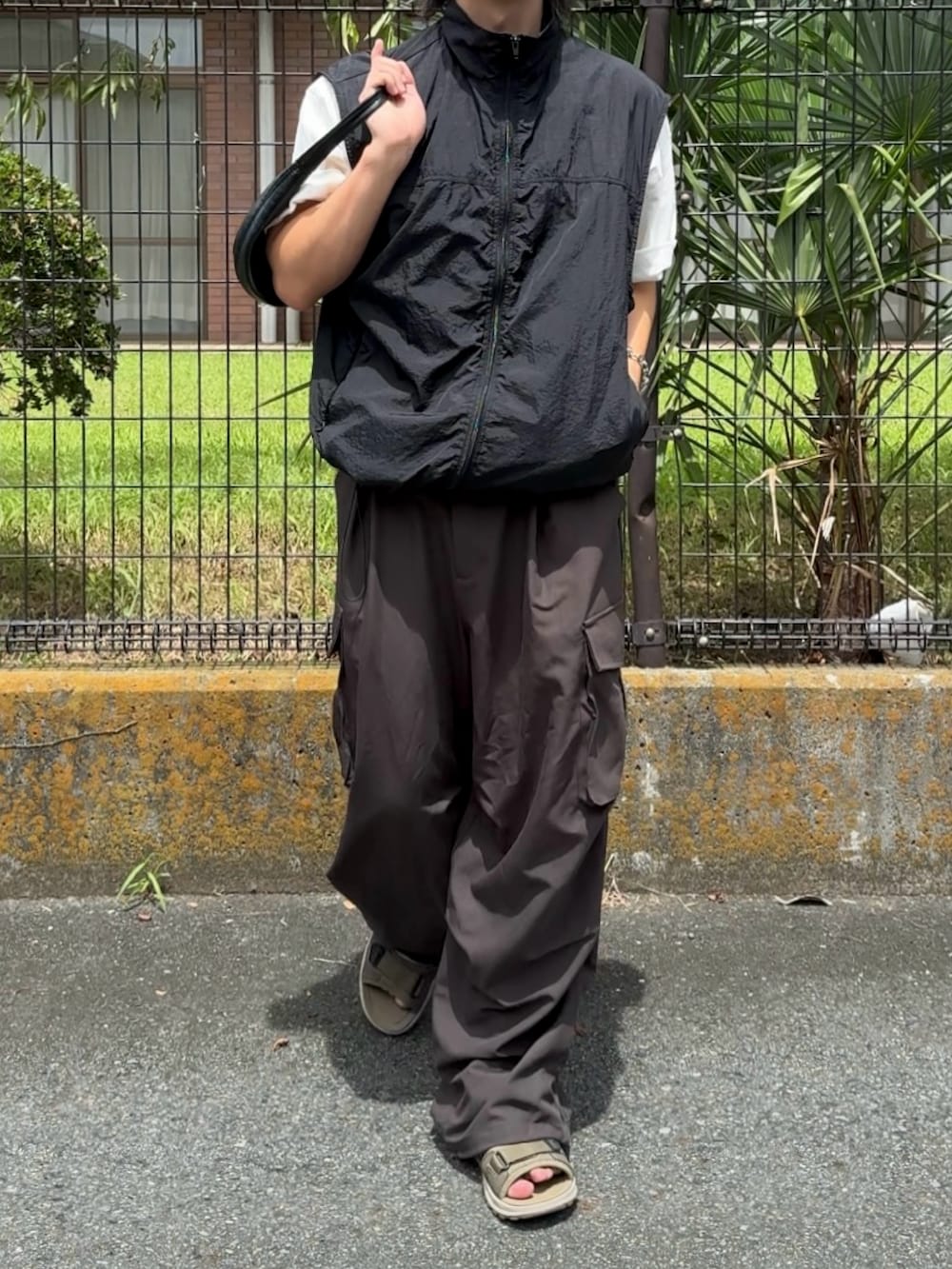 グレー系のその他パンツ、グリーン系のサンダル、ホワイト系のTシャツ/カットソーを着用したメンズの夏コーディネートの2枚目の写真