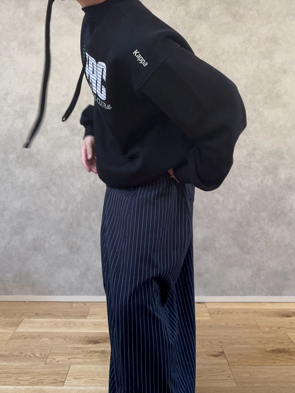 レッド系のスニーカー、ブルー系のスラックス、ブラック系のスウェットを着用したメンズの秋コーディネートの3枚目の写真