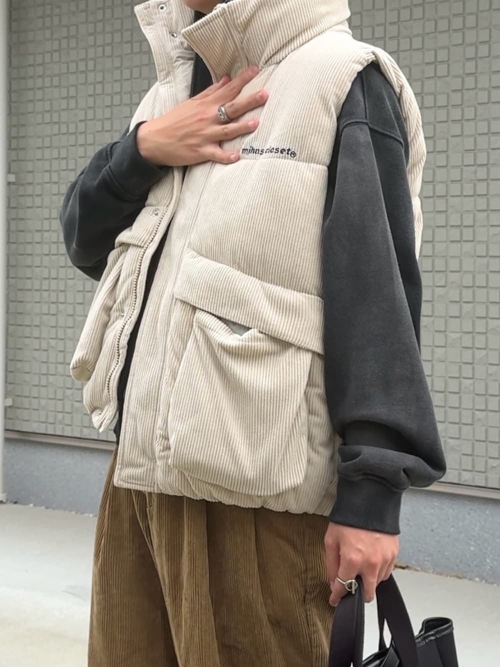 ブラック系のトートバッグ、ベージュ系のその他パンツ、ブラウン系のスニーカーを着用したメンズの秋コーディネートの3枚目の写真