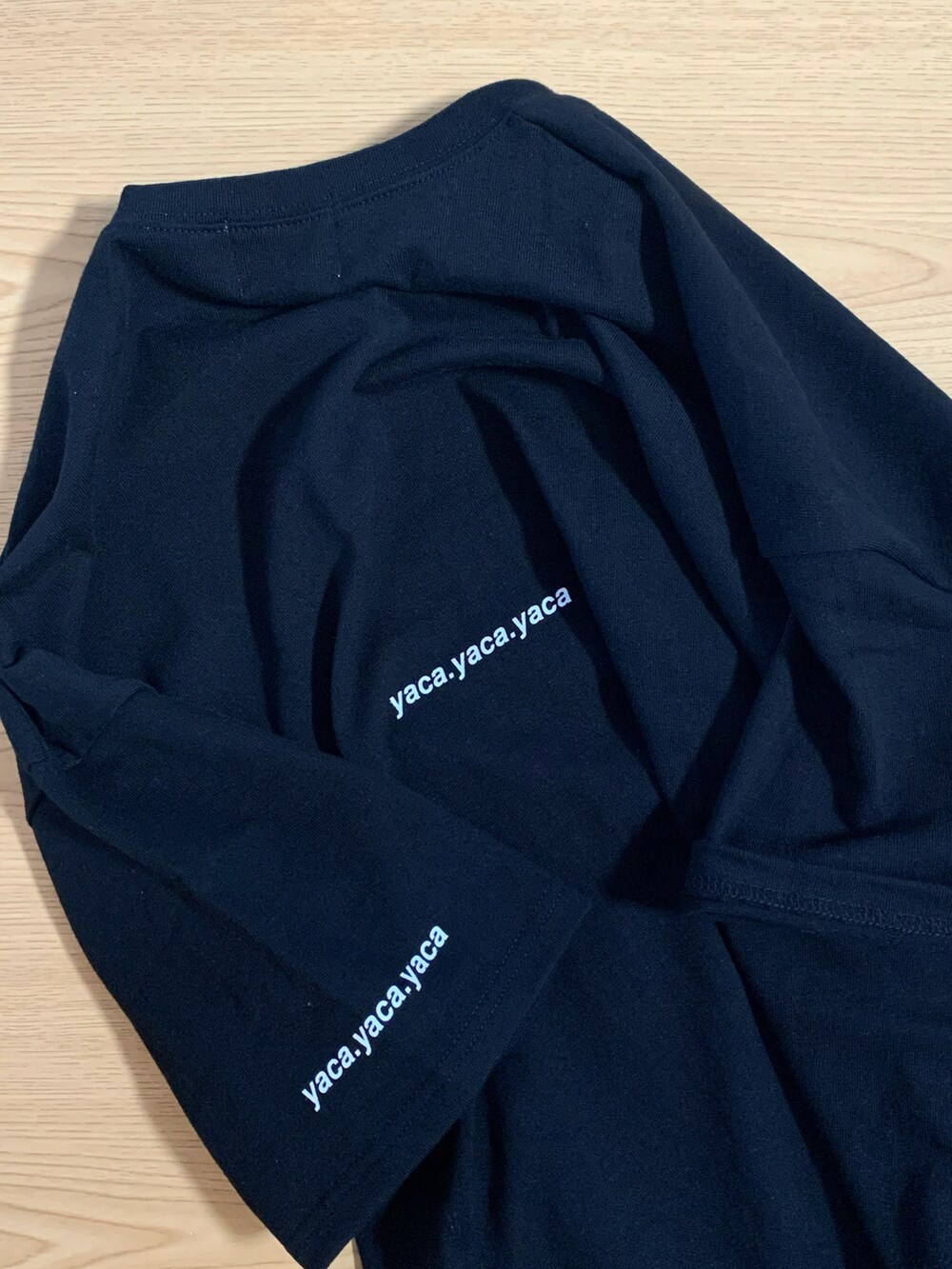 ブラック系のTシャツ/カットソー、ブルー系のデニムパンツ、ブラック系のスニーカーを着用したメンズの春コーディネートの3枚目の写真