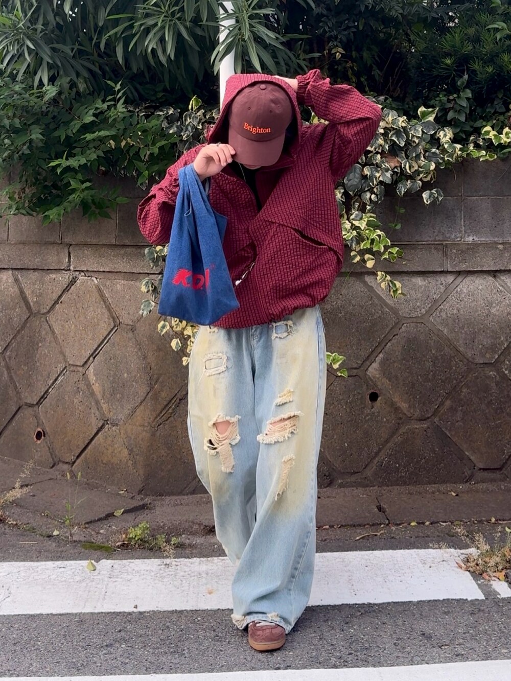 ブルー系のデニムパンツ、レッド系のブルゾン、ブルー系のショルダーバッグを着用したメンズの秋コーディネートの4枚目の写真